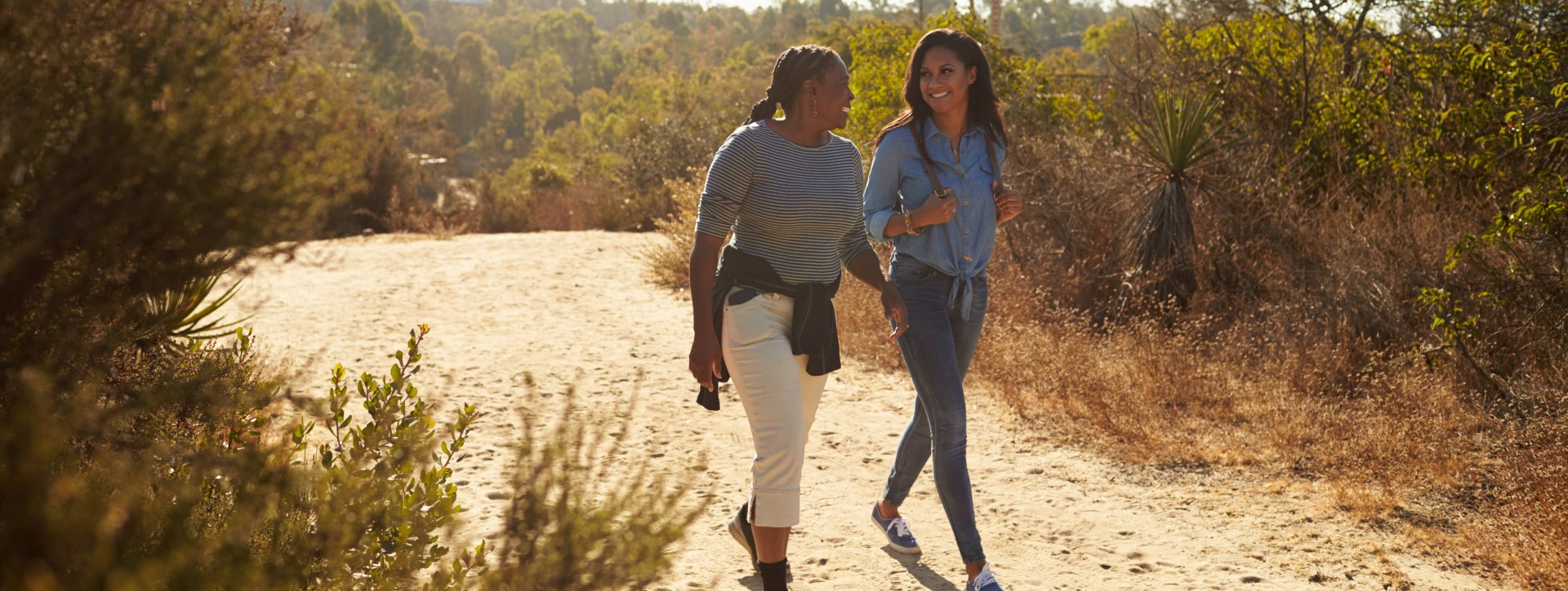 Mother And Adult Daughter Hiking Outdoors In Countryside